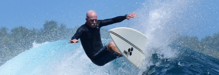 A picture of a surfer aggressively ridng a wave in the ocean.